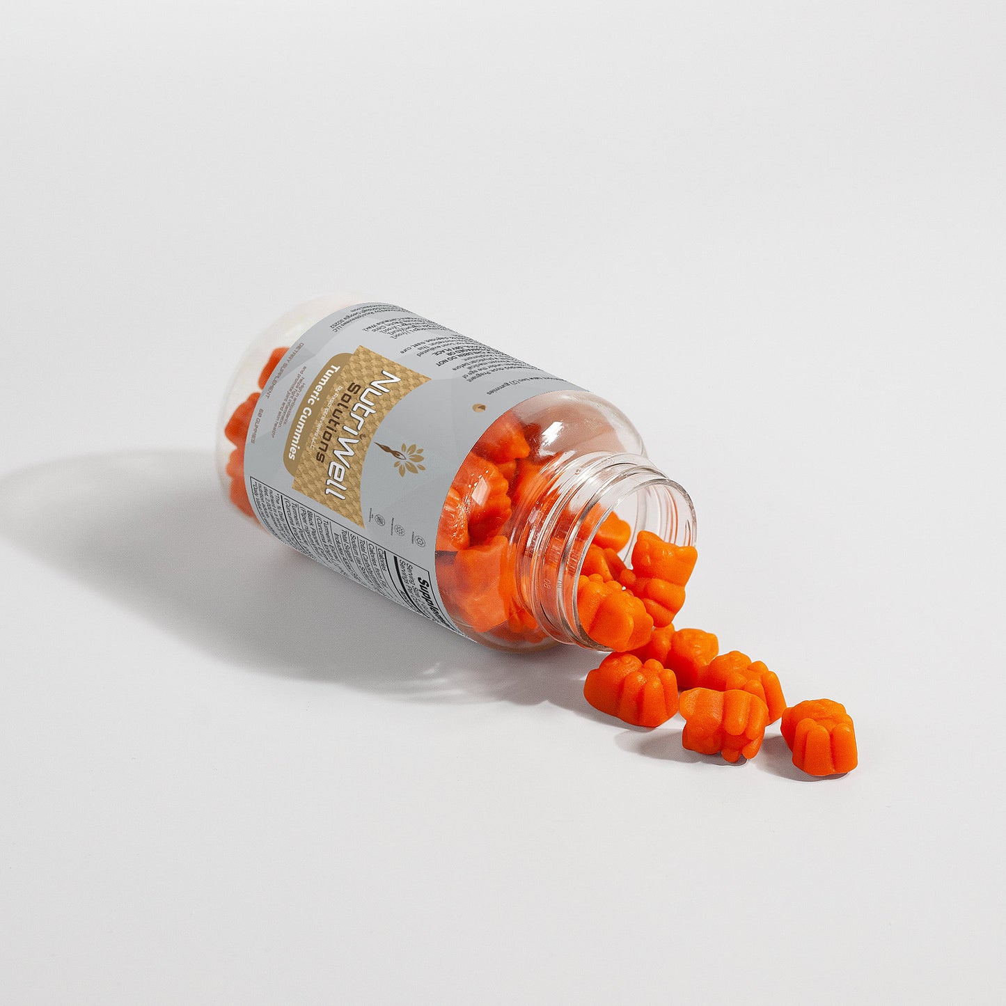 a bottle of NutriWell Solutions Turmeric Gummies open with gummies pouring out 